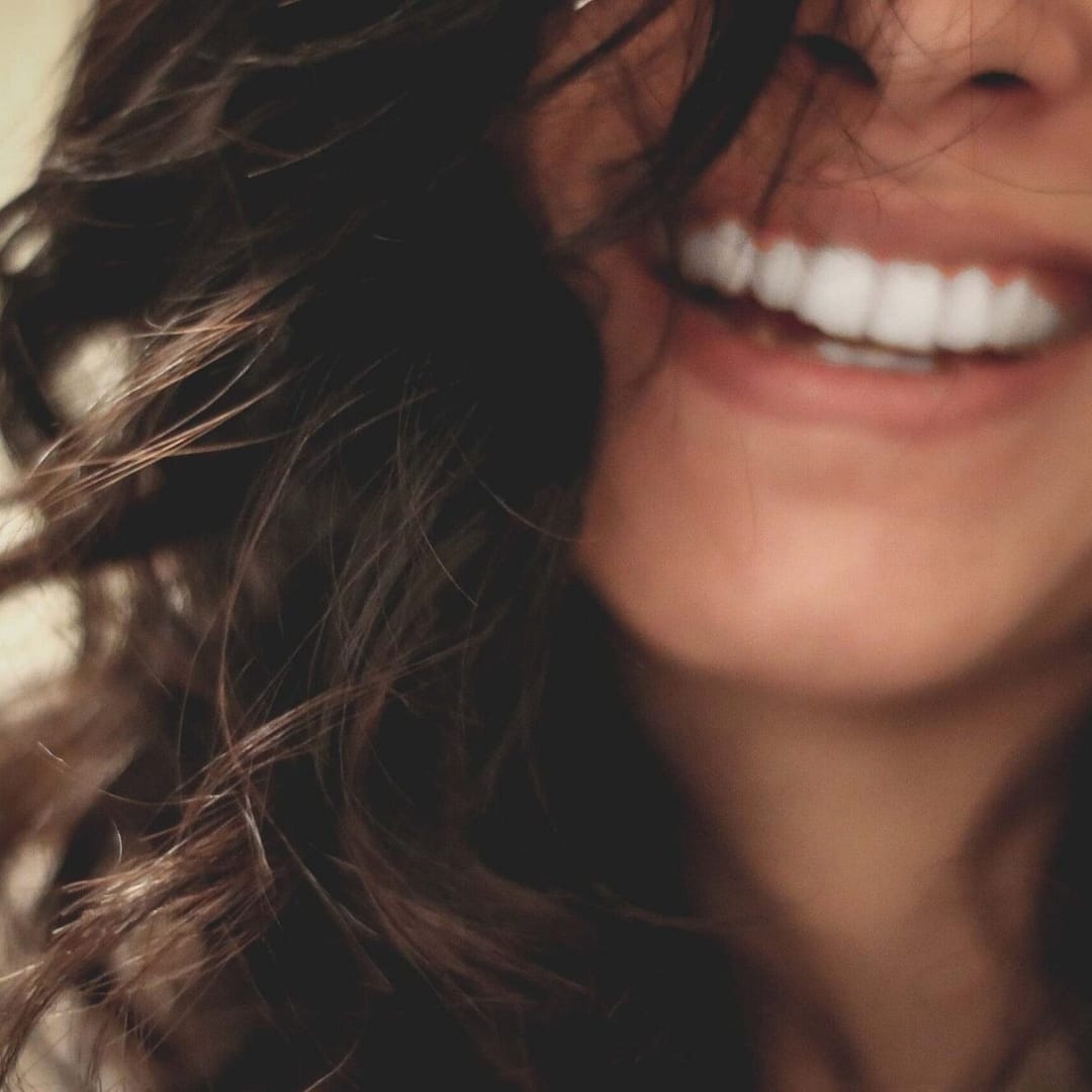 LADY SMILING BACKGROUND HITCHIN DENTAL PRACTICE scaled e1619825521270 uai